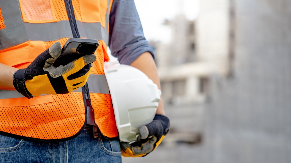 Construction,Worker,Man,With,Orange,Reflective,Vest,Holding,White,Protective