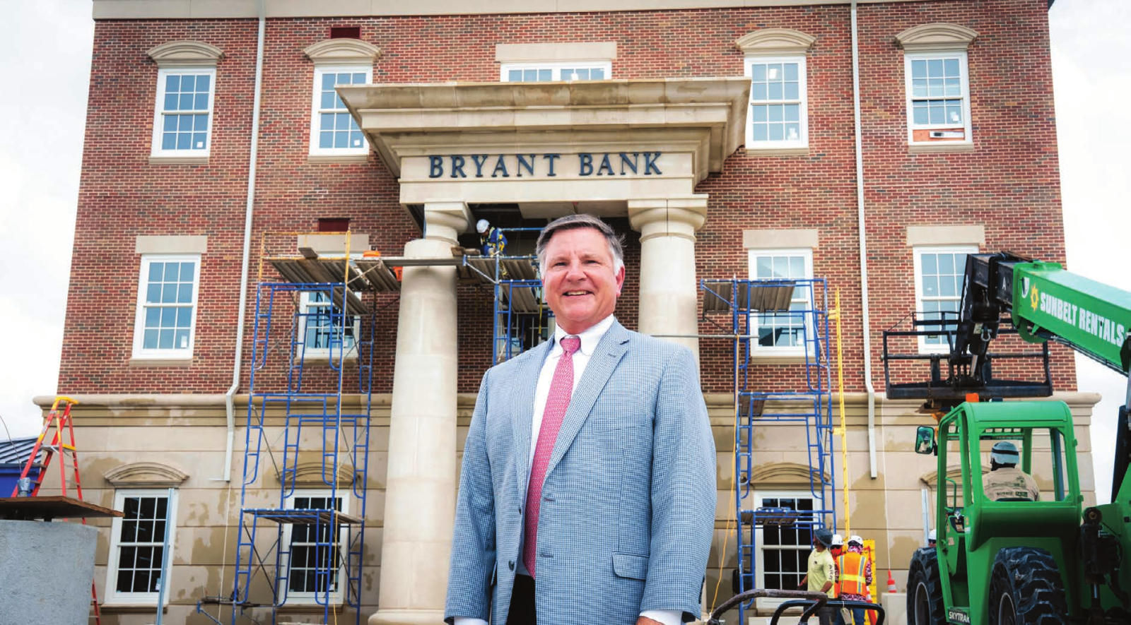 Michael Holland standing in front of the Bryant Bank building under construction on Dauphin Street