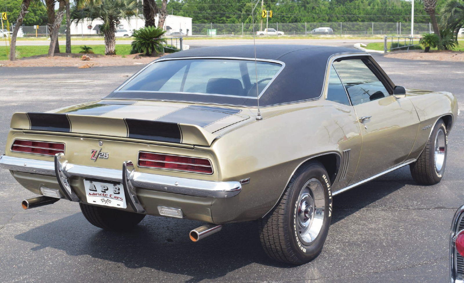 Rear three-quarter view of a vintage gold Z/28 Chevrolet in a parking lot