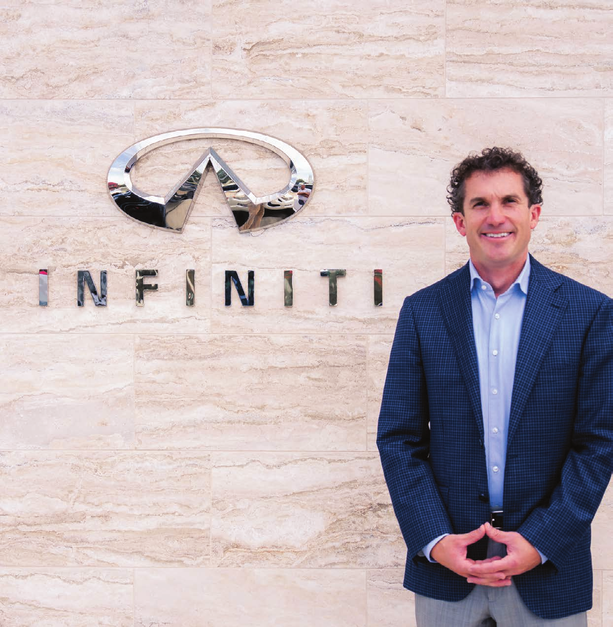 Ty Bullard standing in front of an Infiniti dealership sign.
