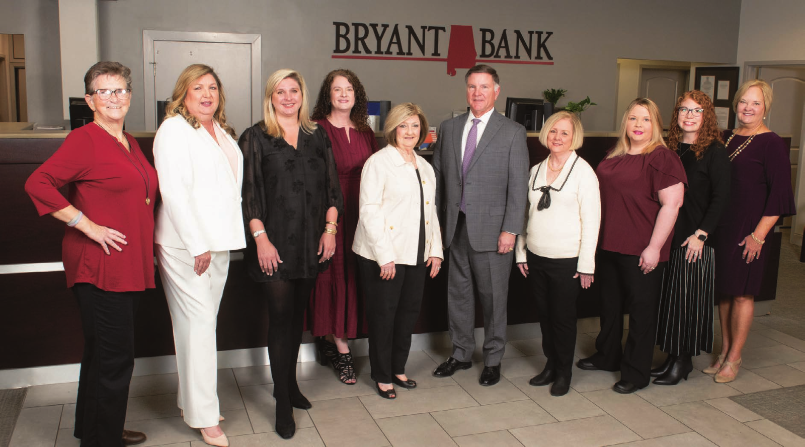 Michael Holland and the Mobile Bryant Bank team posing together inside their previous Airport Boulevard headquarters