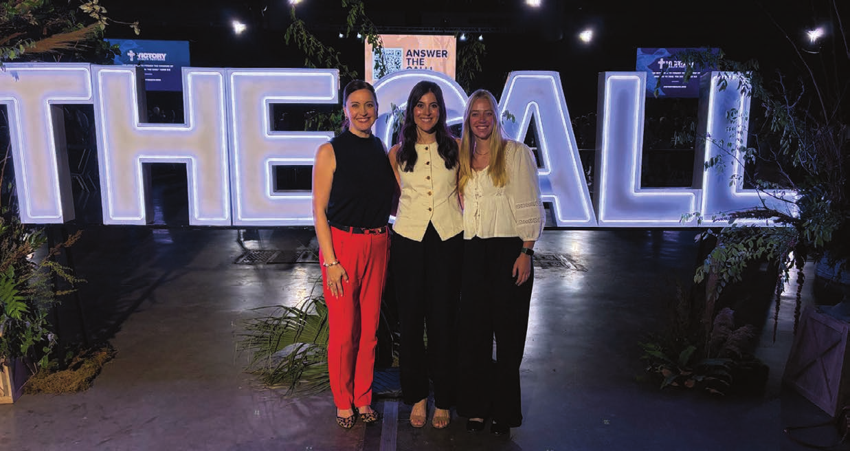 Sarah Jones and two Mobile team members standing in front of a large illuminated sign at the Victory Health Hope for Healing 2026 fundraising gala