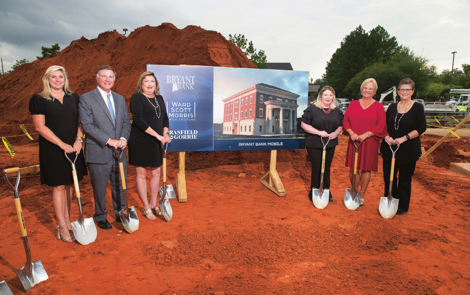 Members of the Mobile Bryant Bank team at the groundbreaking ceremony for the new branch, holding shovels in front of a project sign