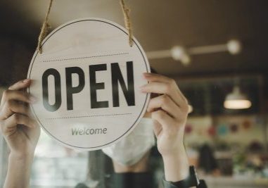 Open. barista, waitress woman wearing protection face mask turning open sign board on glass door in modern cafe coffee shop, cafe restaurant, retail store, small business owner, food and drink concept