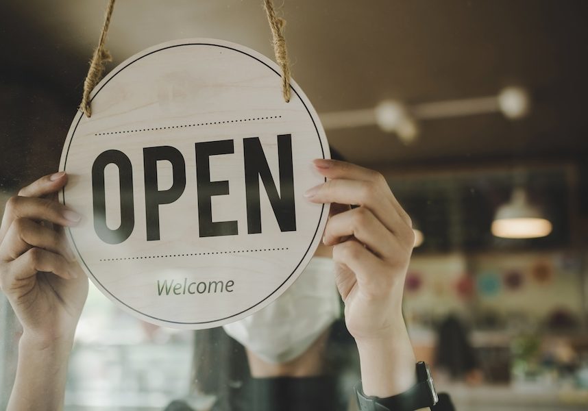 Open. barista, waitress woman wearing protection face mask turning open sign board on glass door in modern cafe coffee shop, cafe restaurant, retail store, small business owner, food and drink concept