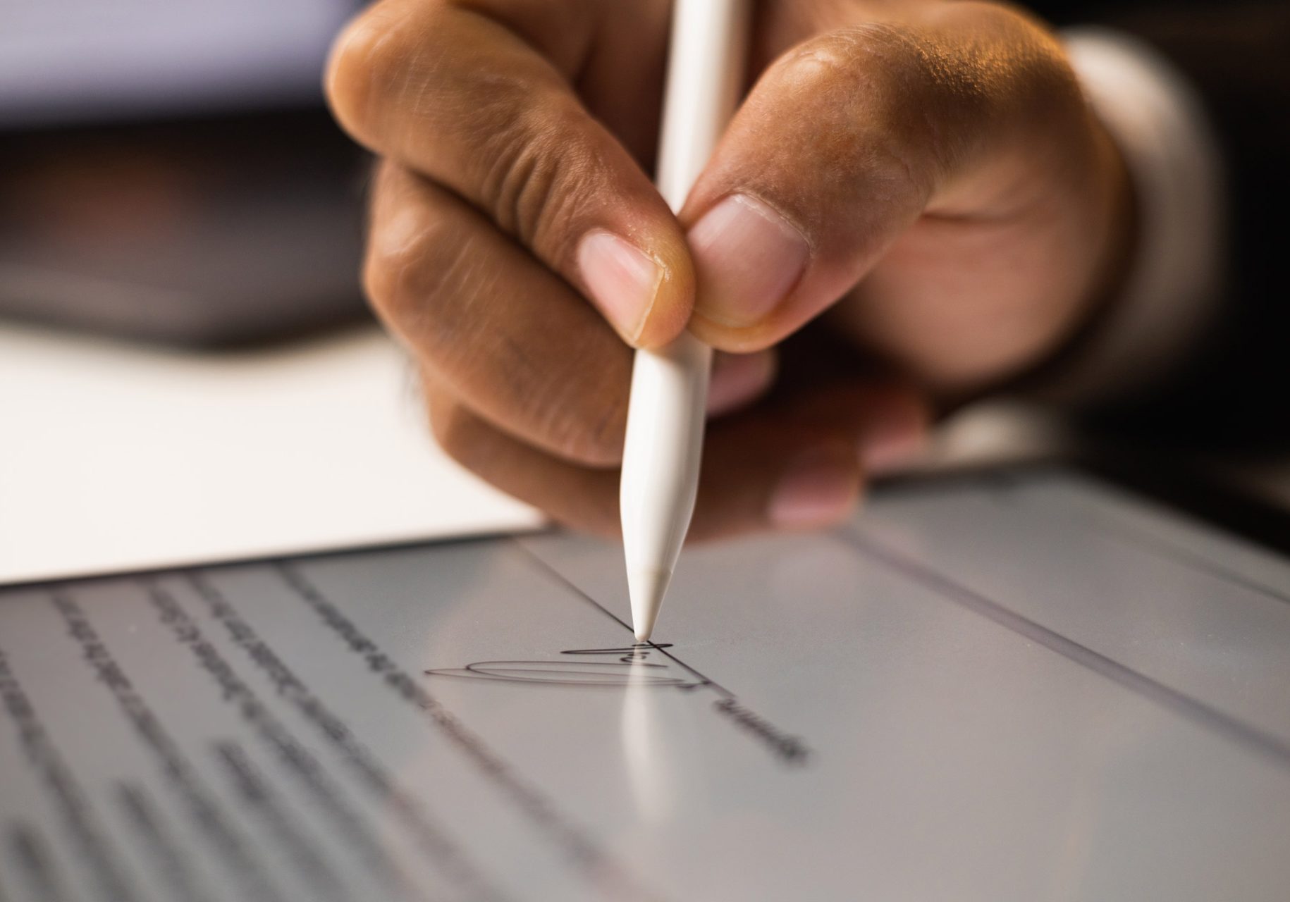 Close up businessman hand electronic Signature on Tablet by Stylus. Write business agreement of contract. Man signing contract on tablet. Business and technology concept.