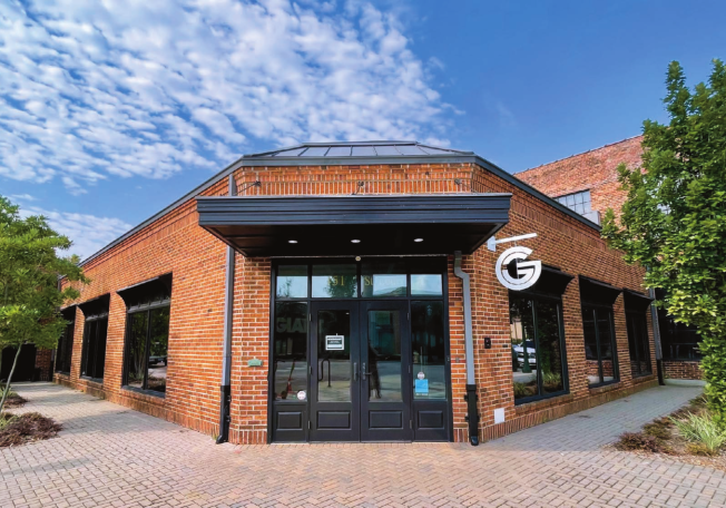 Exterior of the Good Giant office building on St. Louis Street in Mobile, a brick building with large windows and a Good Giant logo sign